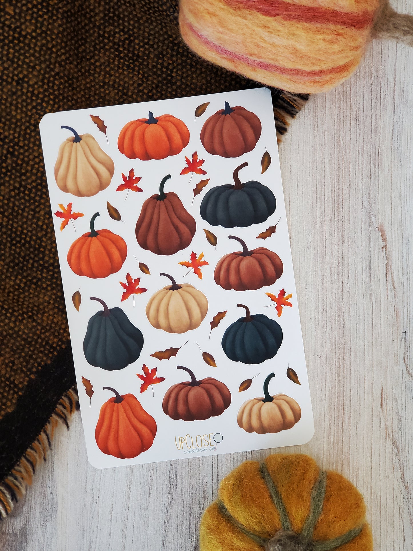 This sticker sheet has pumpkins of different shapes in colors of deep blue, orange, mauve and cream.