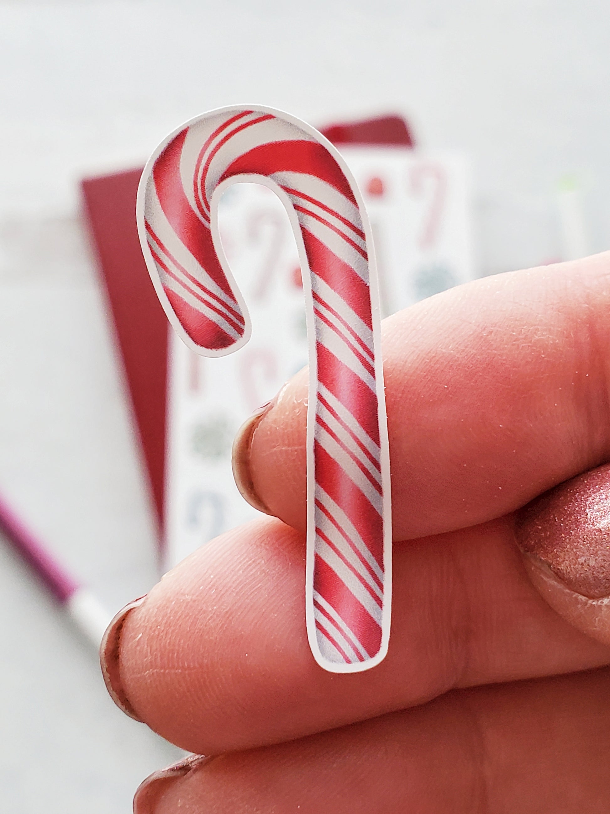 Close up of a pink striped candy cane sticker.
