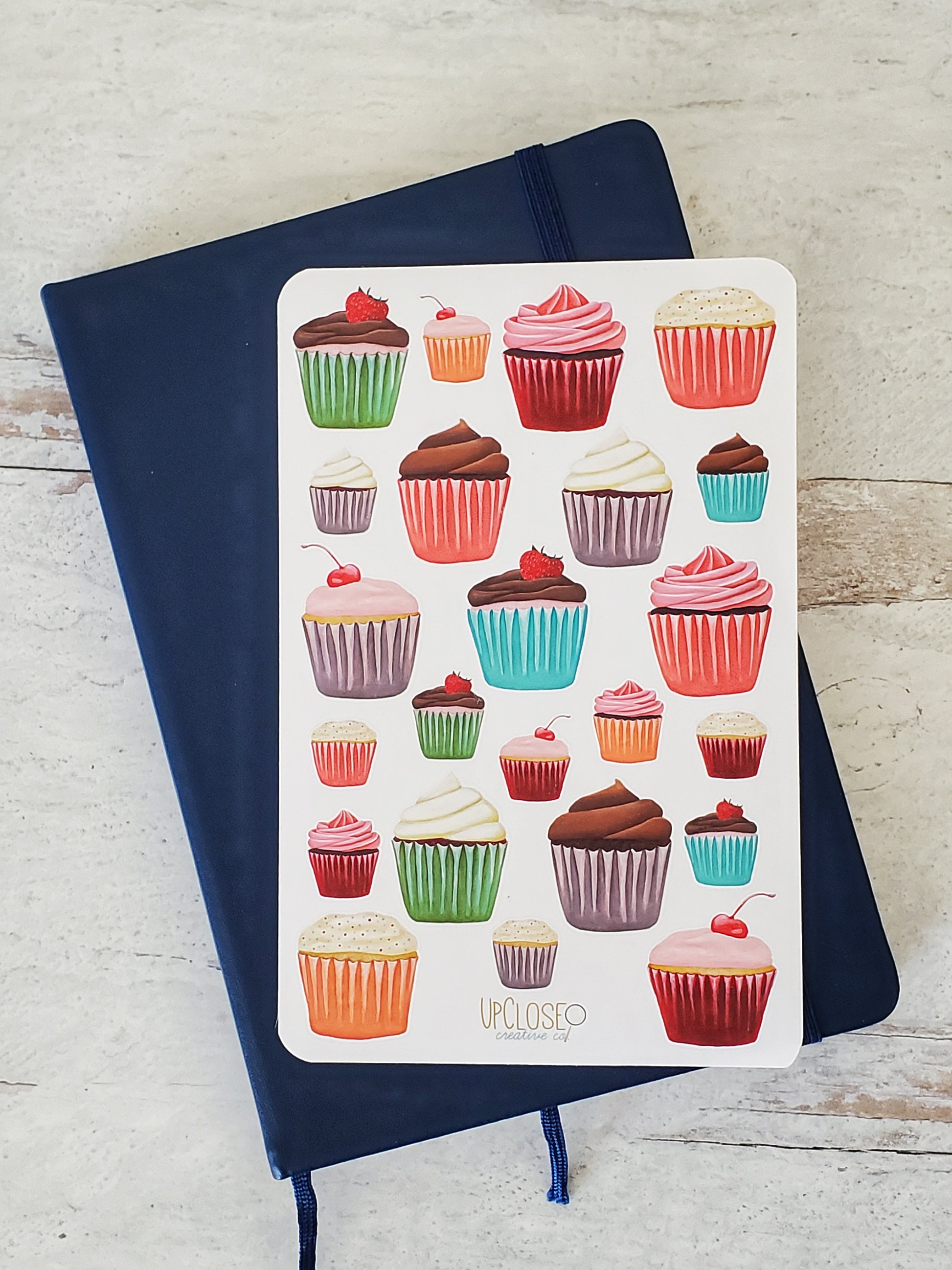This sticker sheet features a variety of illustrated cupcakes with colorful wrappers, red, purple, orange, green and pink.