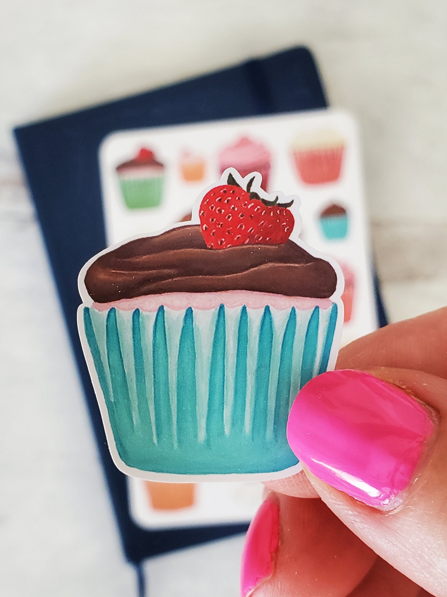A close up of the chocolate frosted strawberry cupcake to show the highly detailed, bold style.