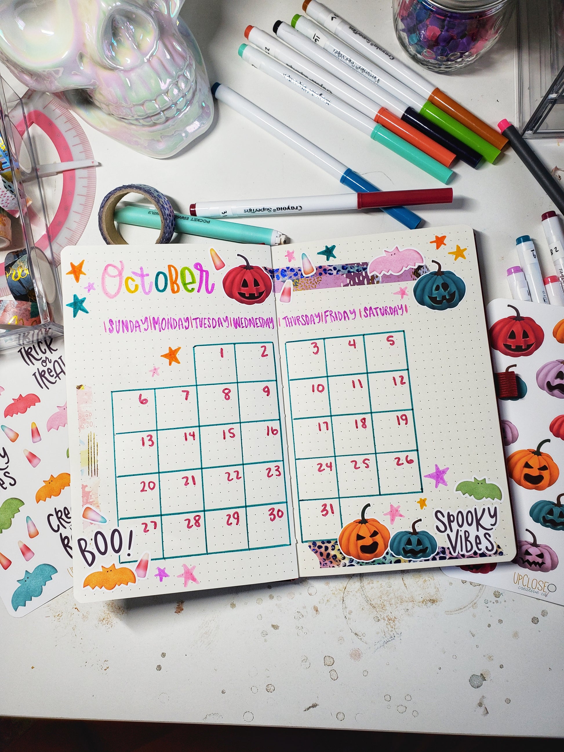 An example of a bullet journal calendar spread decorated with the Trick or Treat sticker bundle stickers.
