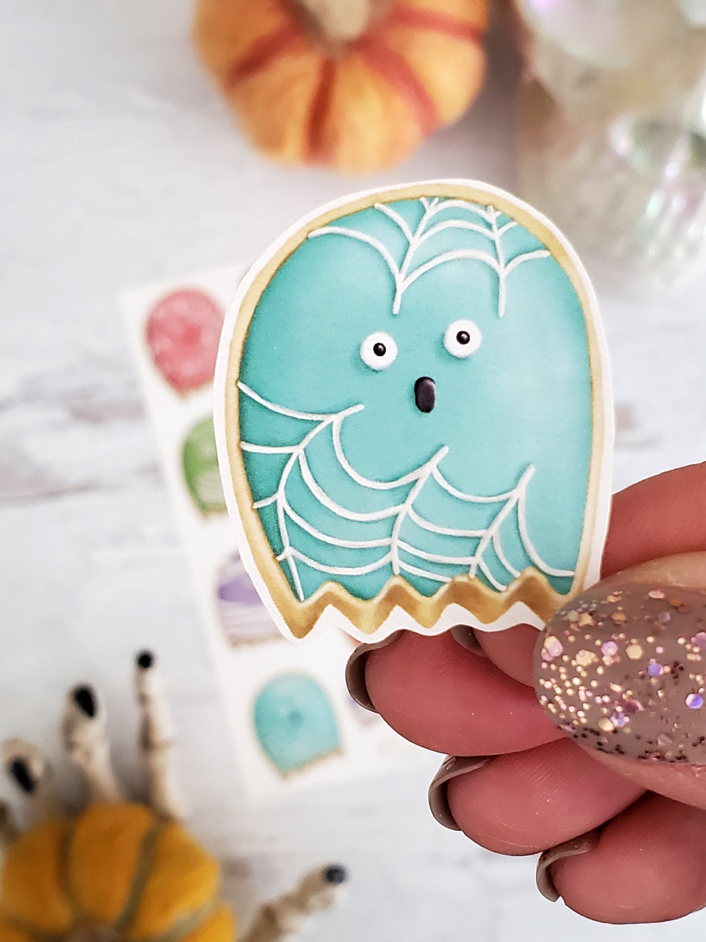 a close up view of the blue spiderweb ghost cookie sticker