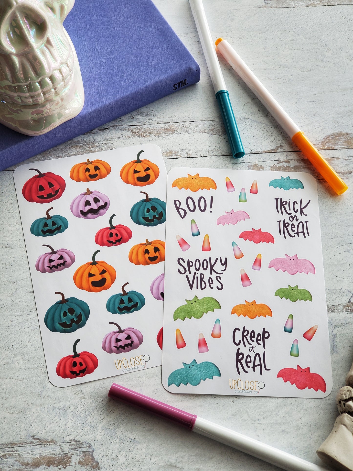 This bundle includes two sticker sheets. One has colorful jack-o-lanterns the other has Halloween candies and phrases. The color palette for both sheets is bright pink, orange, green, blue and purple. 