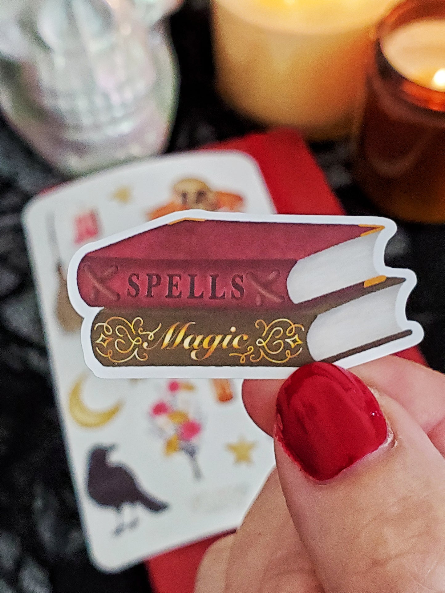 Close up of a sticker: a red book of spells and green book of magic stacked on top of each other